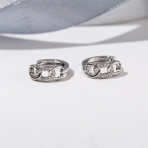 Macro detail of silver-colored chain hoop earrings with micro-pave zircon crystals