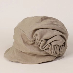 Close-up of pleated linen fabric texture on an earthy brown retro newsboy cap