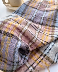 Close-up of soft plaid scarf fabric with pastel check patterns and woven texture