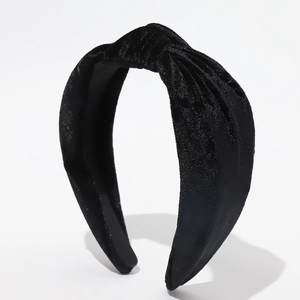 Macro shot of black velvet headband featuring a stylish top knot and soft texture