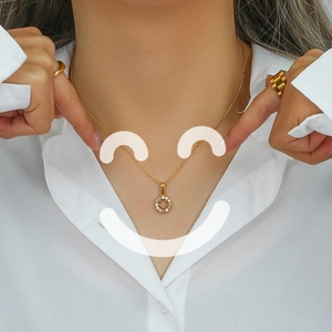 Detail view of 18K gold plated necklace with zircon hollow smiley face pendant on a model