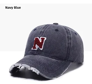 Close-up of navy blue distressed baseball cap with red N letter embroidery and worn edges