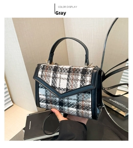 Detail der grauen Karomustertasche aus Wolle mit schwarzem Rand und Metallverschluss