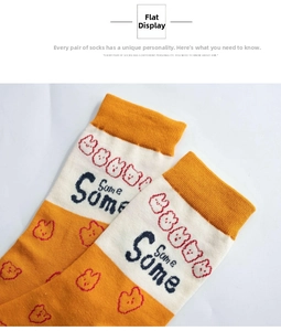 Detail of yellow and white knit mid-calf socks featuring a cute bear pattern and text
