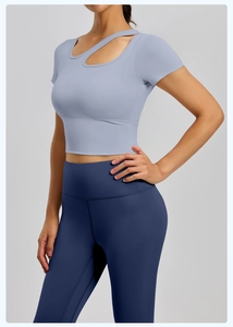 Dettaglio del crop top azzurro a maniche corte e leggings yoga a vita alta
