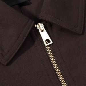 Detailed close-up of dark brown casual jacket with high-quality golden metal zipper detail
