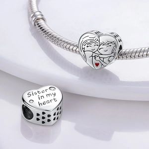 Detail of silver heart charm with Sister in my heart engraving and hugging figure