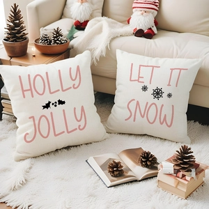 Pink Christmas pillow covers with festive lettering on soft white faux fur rug
