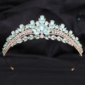 Detailed macro view of golden bridal tiara with opal-like blue stones and sparkling rhinestones