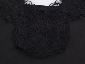 Close-up of intricate black lace trim and satin texture on a camisole top