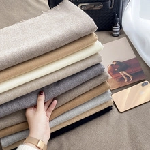 Close-up of neatly folded thick cashmere-feel scarves in various neutral solid colors