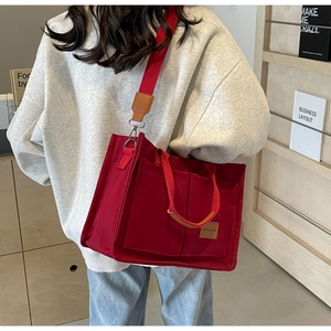 Borsa tote in tela rossa a tracolla con tasche anteriori e dettagli in pelle marrone