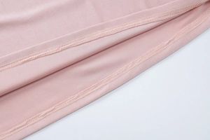 Detailed close-up of double-needle stitching and high-quality seams on pink evening dress