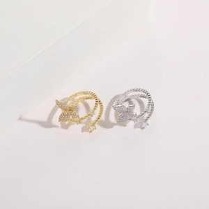 Detailed macro view of 14K gold butterfly zircon rings with beaded bands and square stones