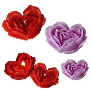 Handmade heart-shaped rose scented candles in red and purple tones on white background
