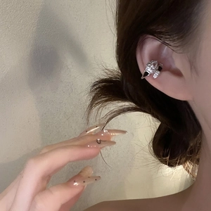 Silver snake ear cuff with black enamel and zircon crystals on model's ear