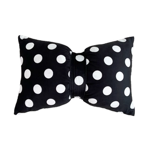 Bow-shaped velvet pillow with white polka dots on black fabric for home decor