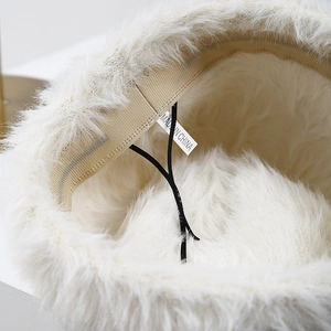 Interior detail of white plush bucket hat with adjustable drawstring and inner sweatband