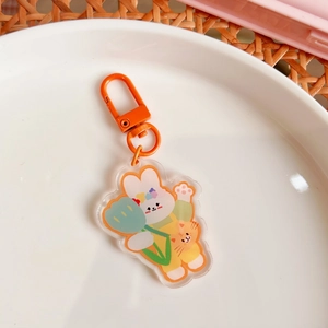 Detailed macro view of cute acrylic rabbit and kitten charm with orange metal hook
