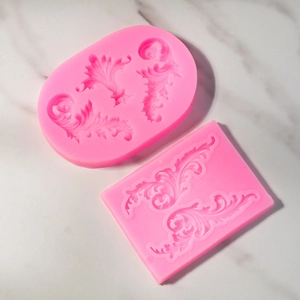 Macro-opname van roze siliconen fondantvormen met verfijnde barokke bloemenreliëfs