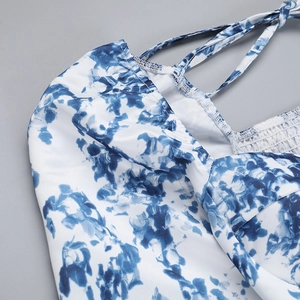 Détail de la robe à imprimé floral bleu avec fines bretelles et dos élastique