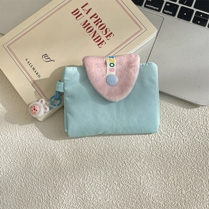 Close-up of cute light blue card holder with pink faux fur flap and white rabbit charm