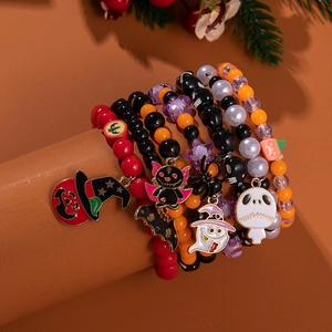 Halloween beaded bracelet set with ghost and pumpkin charms on a festive background