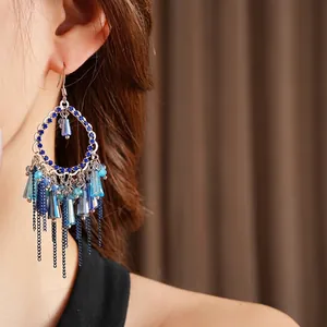 Orecchini bohémien vintage con cristalli blu e frange argentate su una modella