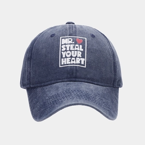 Detail of Mr. Steal Your Heart print with a red heart on navy washed denim baseball cap