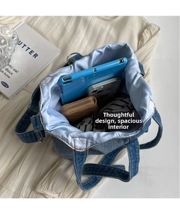 Spacious interior of denim tote bag with light blue lining holding a tablet and phone
