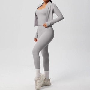 Detailed close-up of a three-piece seamless yoga set in light grey with a zip jacket