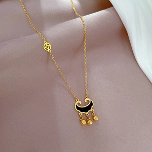 Detailed shot of golden titanium steel ruyi lock necklace with black enamel and bells