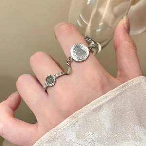 Close-up of zircon resin gourd flower rings on hand holding a glass cup