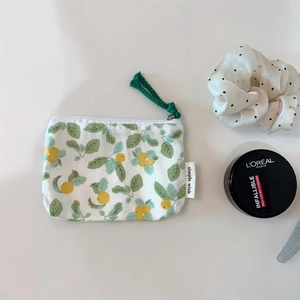 Detailed close-up of a floral cotton mini pouch with fruit pattern and woven rope zip pull