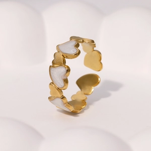 Detailaufnahme des vergoldeten Edelstahlrings mit Herzen und weißer Emaille
