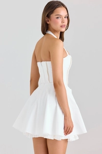 Vue latérale d'une mini robe blanche à licou avec ourlet plissé et haut boutonné