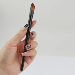 Angled concealer brush with fiber bristles and black handle for precise makeup contouring