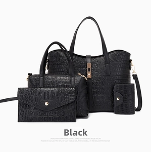 Detail view of black 4-piece handbag set with textured crocodile pattern and gold hardware