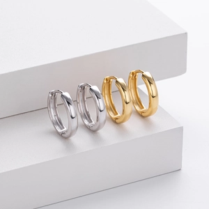 Detailed macro view of polished gold and silver S925 sterling silver hoop earrings