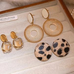 Detailed close-up of vintage earrings set including pearl and leopard print styles