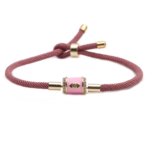 Close-up of pink adjustable cord bracelet with rhinestone evil eye charm and gold sliders