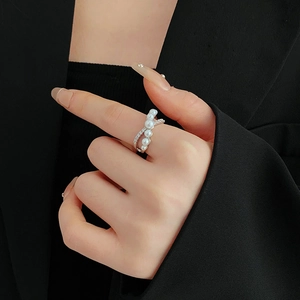 Detailed view of silver cross ring featuring sparkling zircons and elegant white pearls