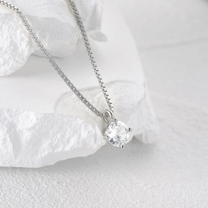 Detailed close-up of a four-prong set cubic zirconia pendant on a silver box chain