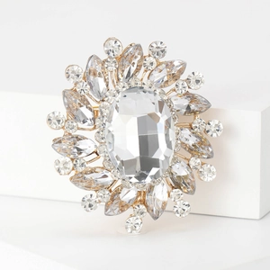 Macro detail of oval crystal brooch with marquise rhinestones in gold setting