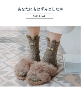 Close-up of cozy coral fleece socks with cat embroidery and plush winter slippers