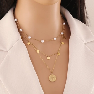 Three-layer gold chain necklace featuring pearls, metal discs, and a coin pendant