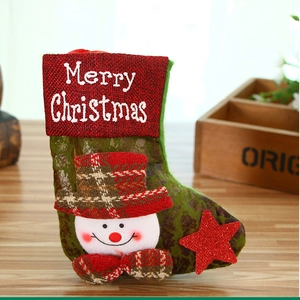 Detail of Christmas stocking with snowman design and Merry Christmas embroidery on a table