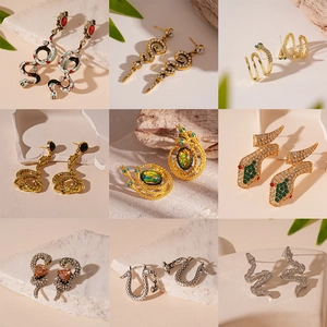 Collection of nine snake-shaped earrings in gold and silver with rhinestones and enamel