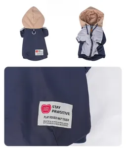 Detail of waterproof navy dog hoodie with Stay Pawsitive label and ribbed cuffs