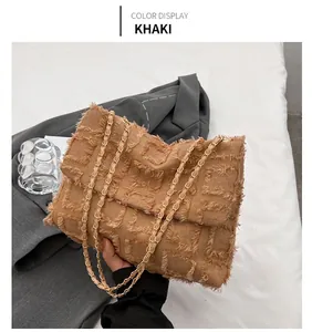 Close-up of khaki tweed crossbody bag with fringe texture and gold chain strap